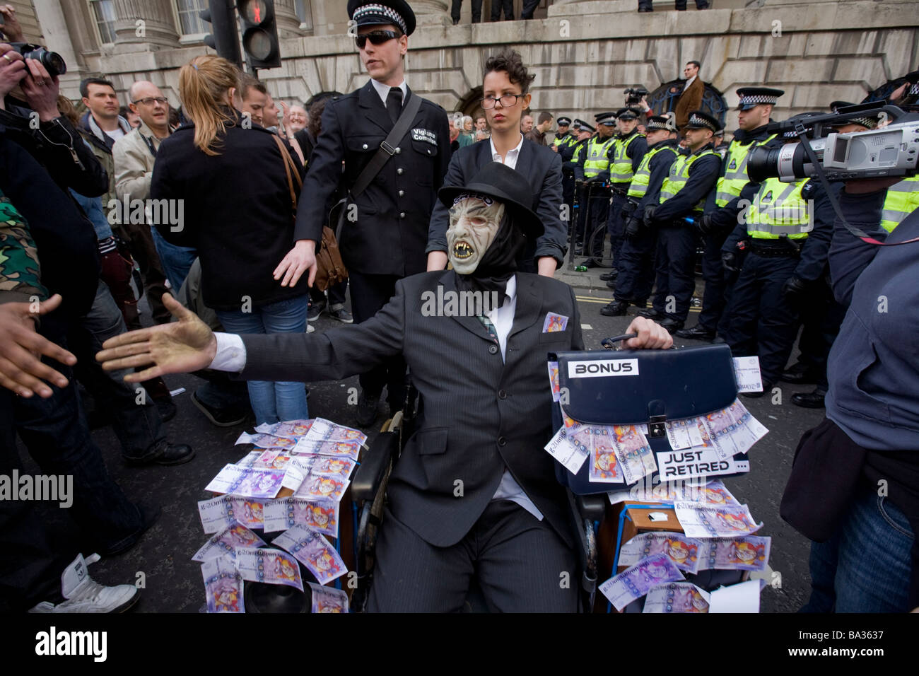 A man with mask and costume in a wheelchair protests banking bonuses at the G20 protest at Bank of England Stock Photo