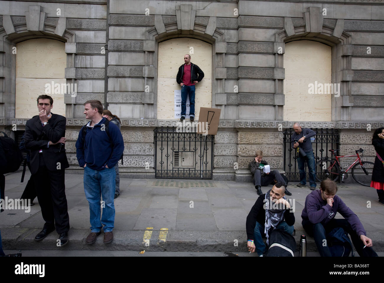 People denied release from the area by police sit on the pavement at G20 protest at Bank of England Stock Photo