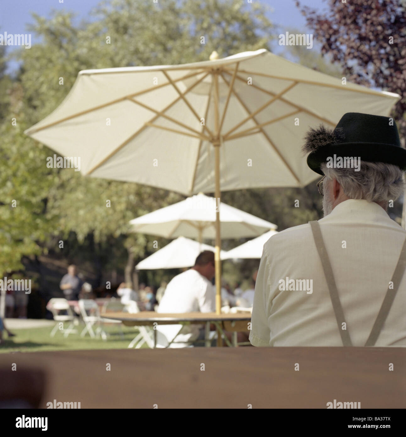 Beer garden parasols man hat back 