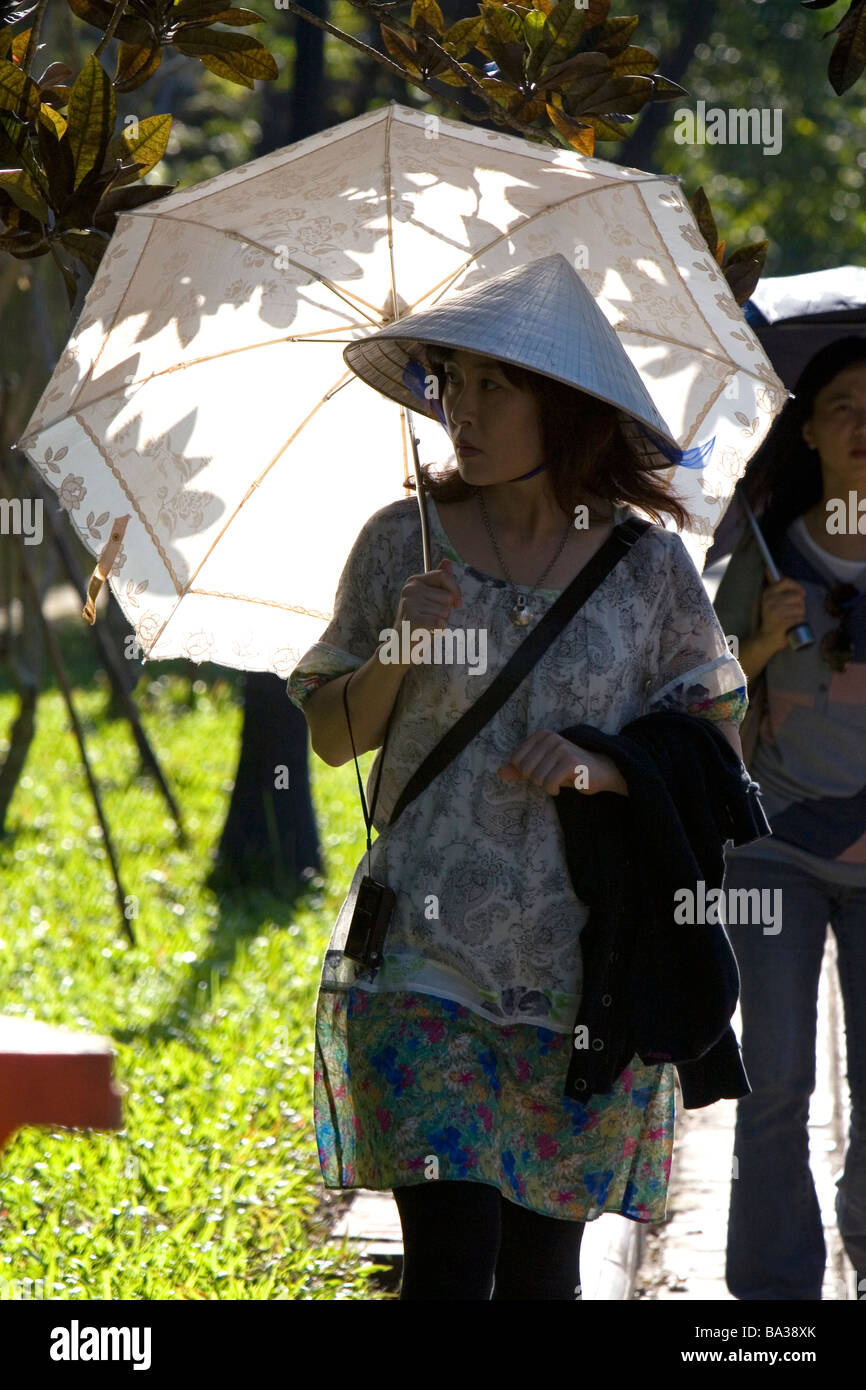 Vietnamese woman walking with an umbrella at the Imperial Citadel of Hue Vietnam Stock Photo
