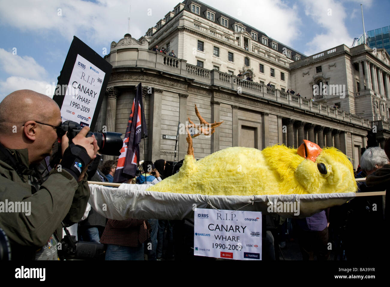 Demonstrators carry a bird on a stretcher illustrating recession at Canary Wharf, at the Bank of England during G20 protest Stock Photo