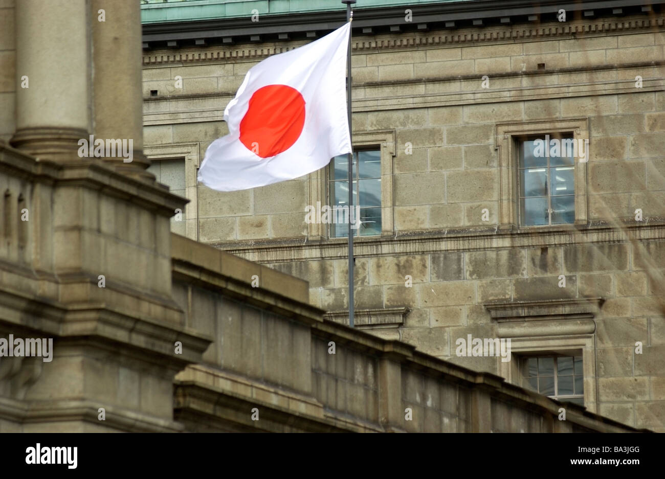 A Japanese flag the Hinomaru flies outside the Bank of Japan in Tokyo Stock Photo