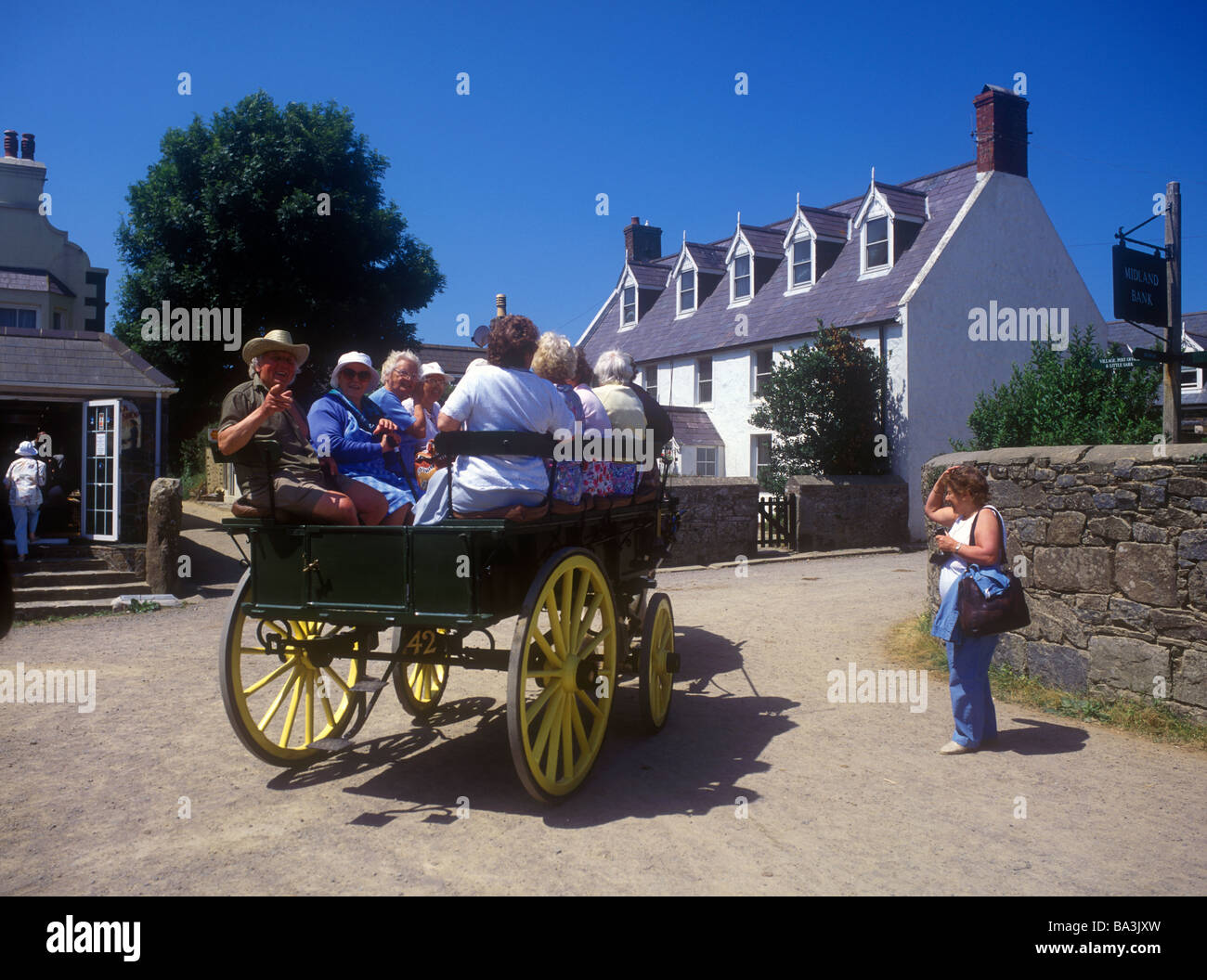 Visitors enjoying a horse and carriage ride around the island of Sark Stock Photo