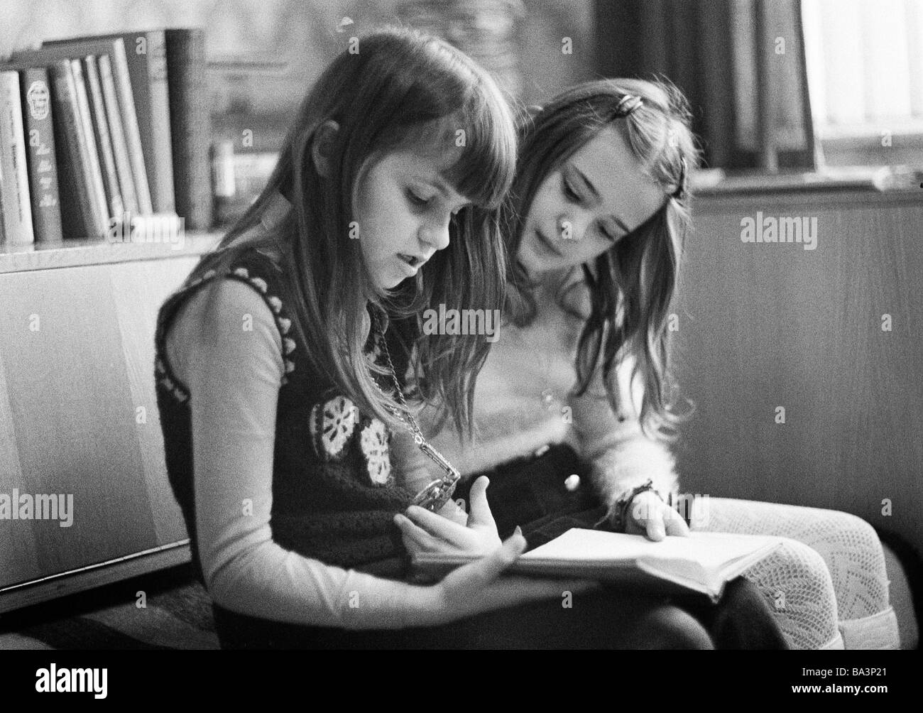Seventies, black and white photo, people, children, two girls sit side by side reading a book, aged 9 to 11 years, Birgit Stock Photo