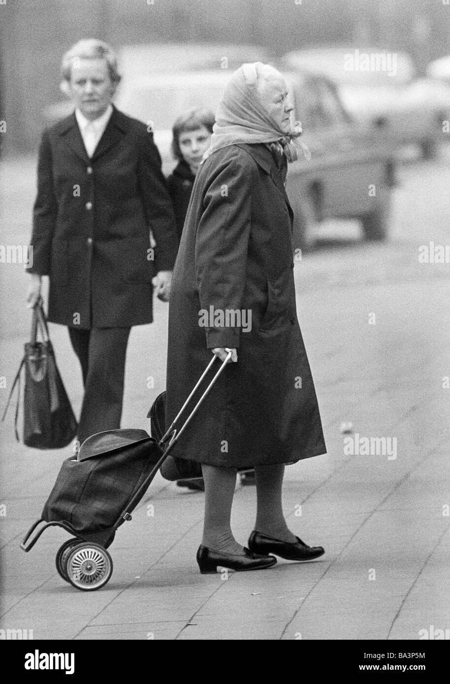 Seventies, black and white photo, people, older woman goes shopping with a shopping trolley, aged 70 to 80 years Stock Photo