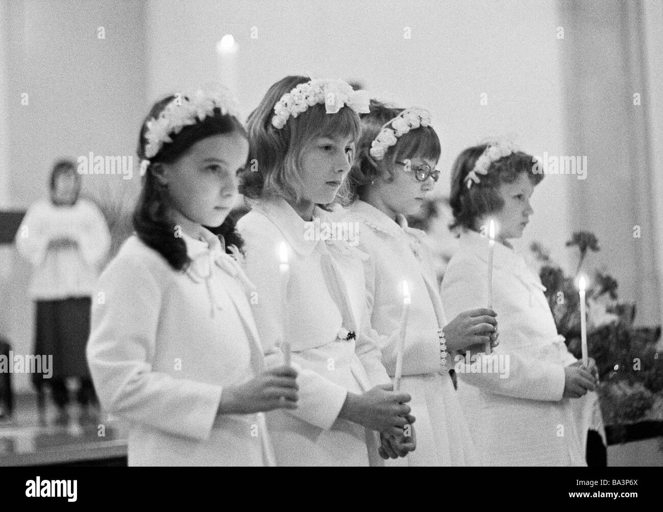 Seventies, black and white photo, religion, Christianity, First Communion, four girls hold candles in the hands, aged 8 to 12 years Stock Photo