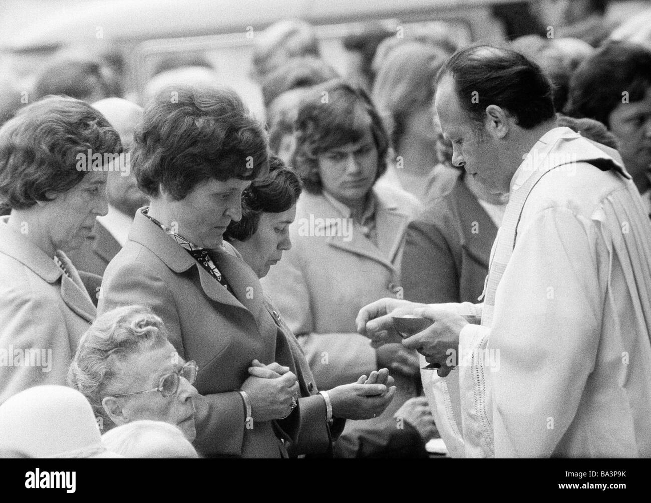 Seventies, black and white photo, religion, Christianity, Corpus Christi, priest administers the Holy Communion to women, aged 40 to 50 years, aged 50 to 70 years Stock Photo