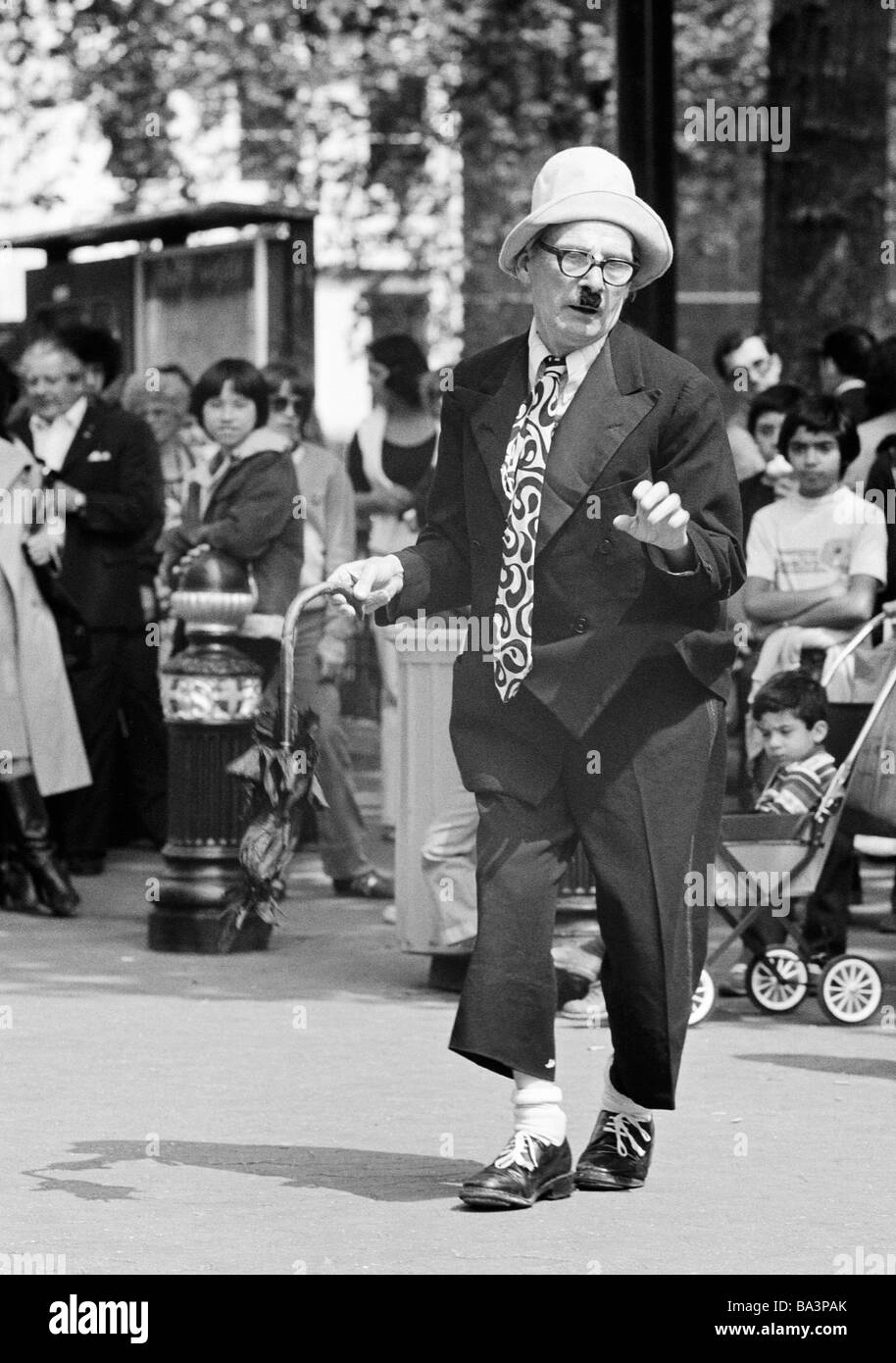 Seventies, black and white photo, humour, people, visitors on a sqare have fun with a costumed comedian, aged 60 to 70 years, Great Britain, England, London Stock Photo