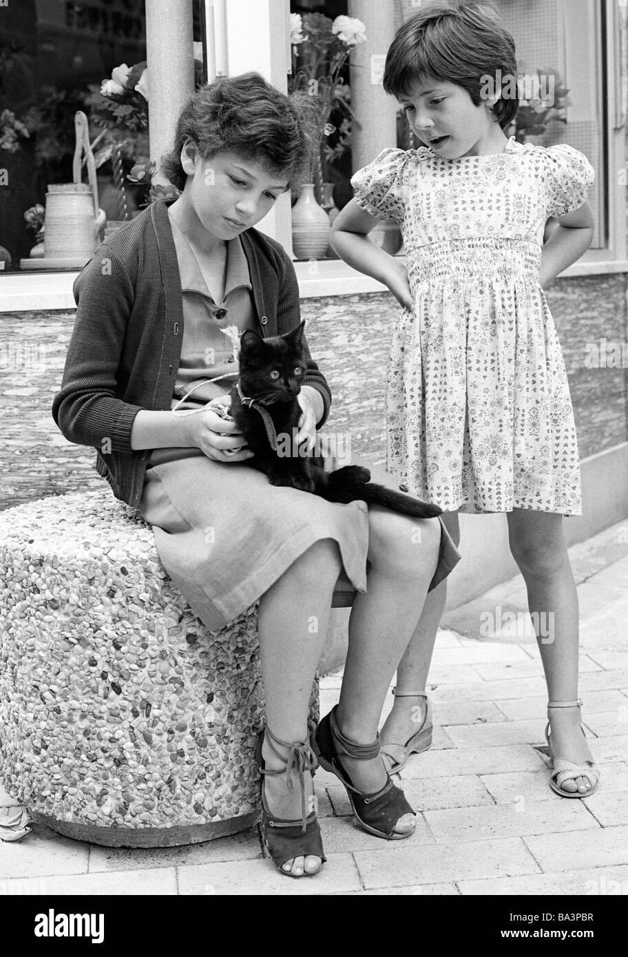 Seventies, black and white photo, people, children, two young girls with a black cat, aged 11 to 13 years, aged 6 to 8 years, France, Loire Valley Stock Photo