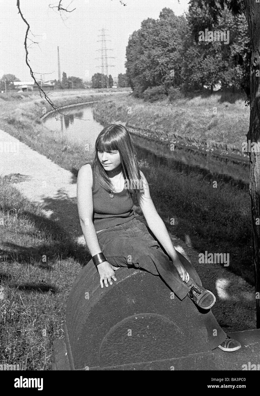 Seventies, black and white photo, people, young girl sits near a river, Emscher, Bottrop, Ruhr area, North Rhine-Westphalia, aged 12 to 14 years Stock Photo