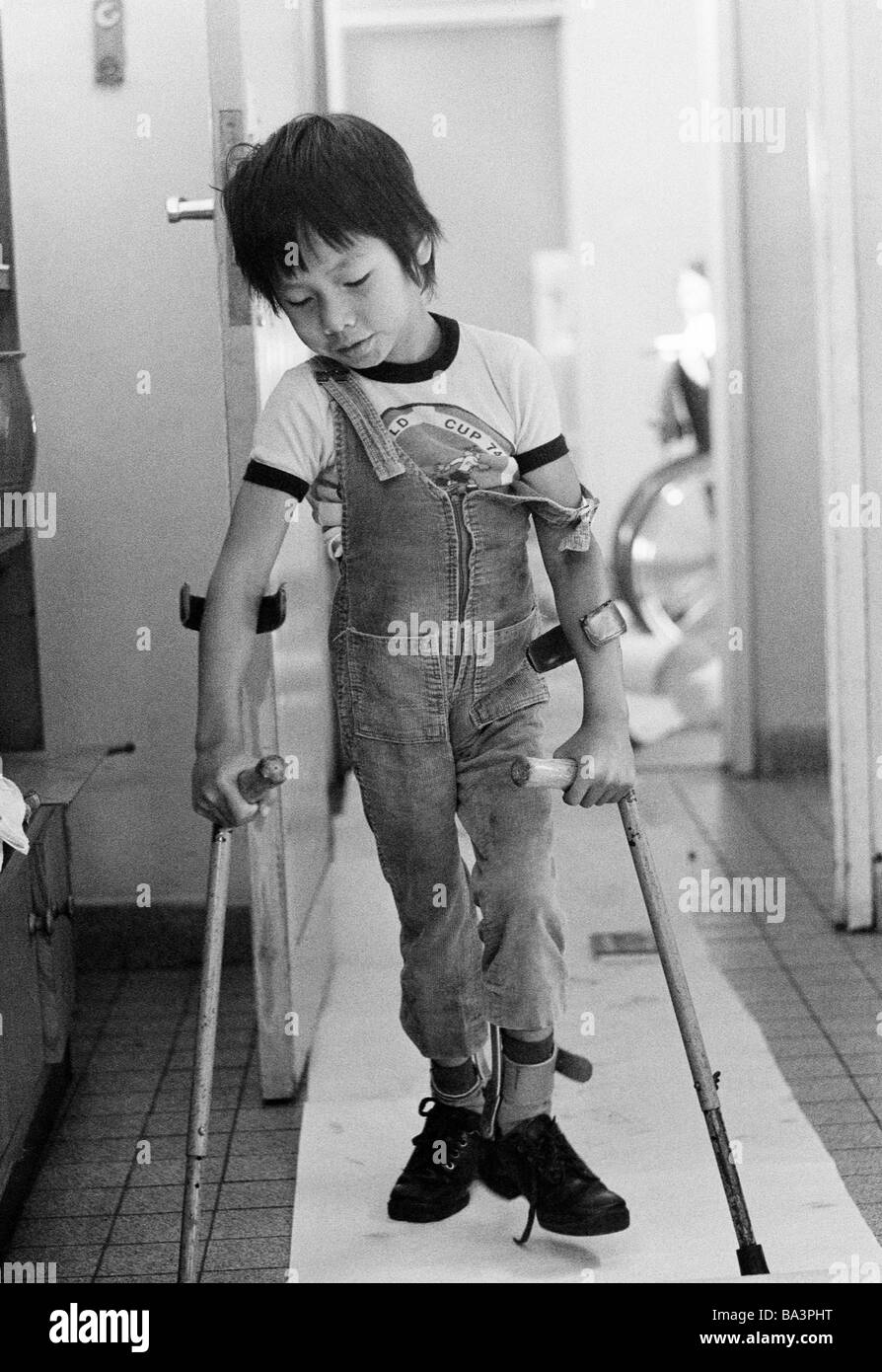 Seventies, black and white photo, people, physical handicap, a boy from Vietnam walks with crutches, aged 6 to 10 years, Tan, Special School Alsbachtal, D-Oberhausen, D-Oberhausen-Sterkrade, Ruhr area, North Rhine-Westphalia Stock Photo