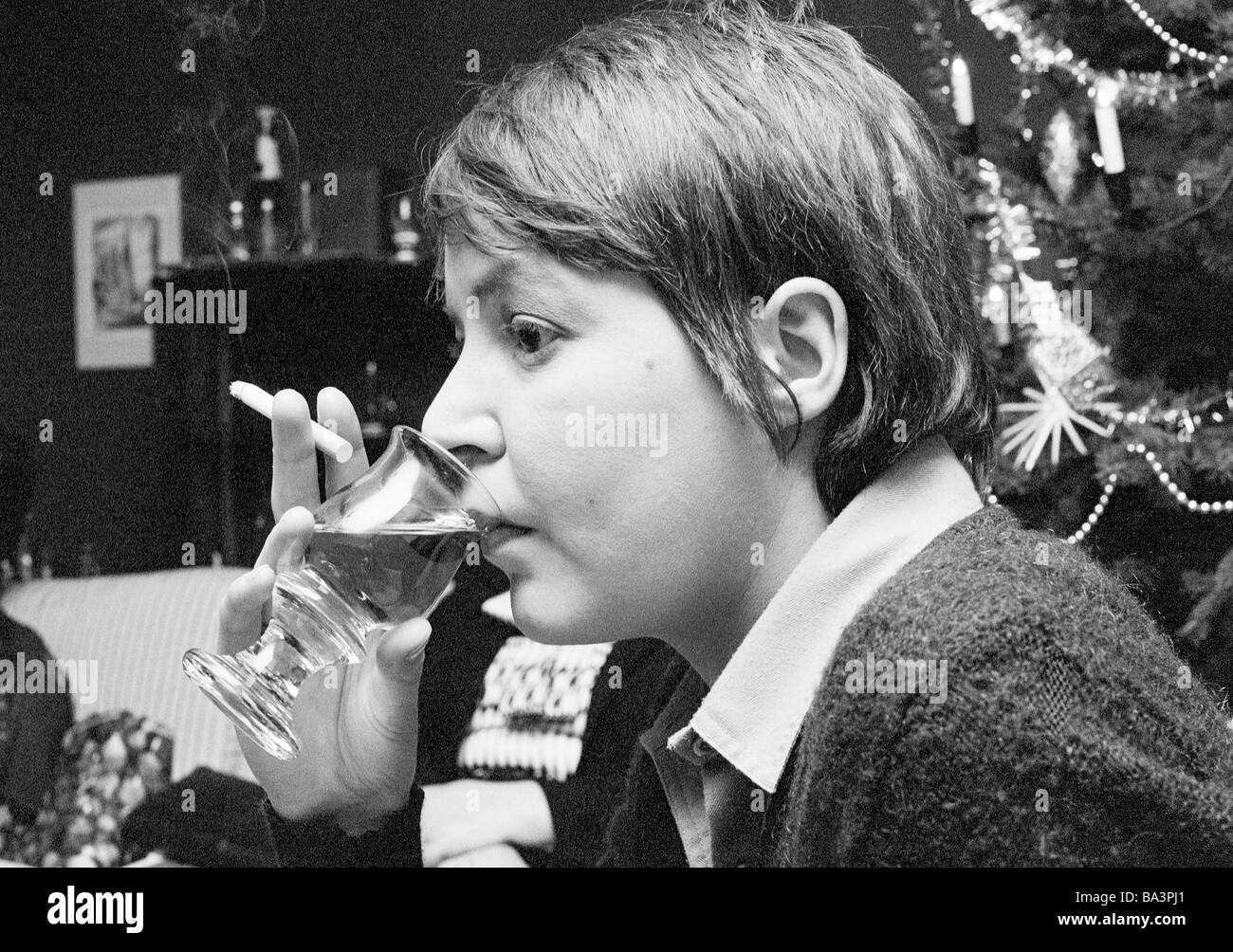 Seventies, black and white photo, people, young woman holds a cigarette and a glass with alcohol in her hand, portrait, aged 25 to 30 years, Monika Stock Photo