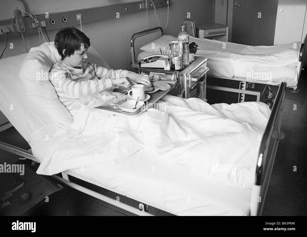 Eighties, black and white photo, people, health, young woman in a hospital, dinner in a sickbed, aged 25 to 30 years, Monika Stock Photo