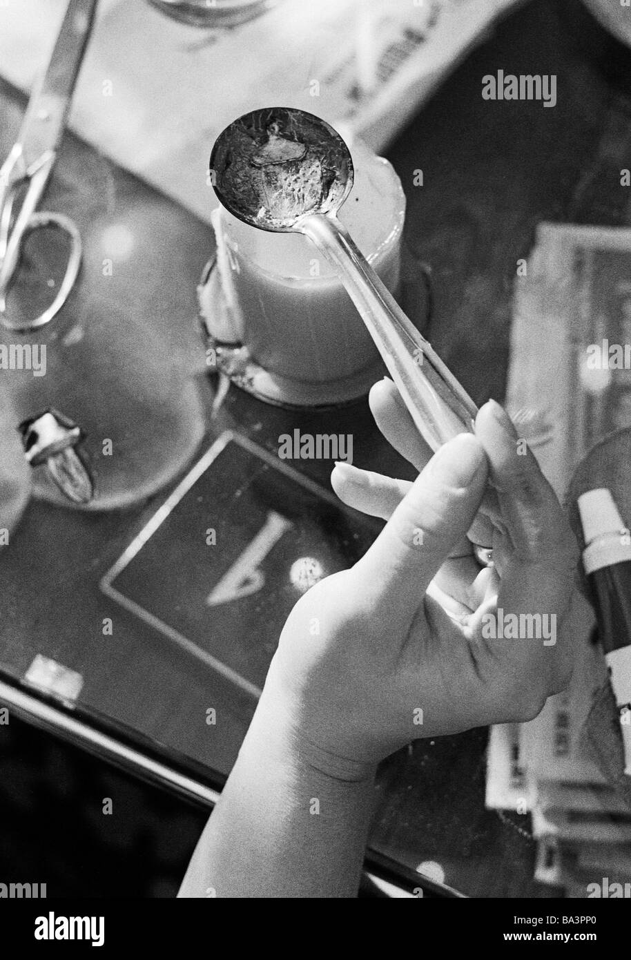 Seventies, black and white photo, people, night of New Years Eve, celebrating New Years, symbolic, soothsay, lead-pouring, hand holds a spoon containing plumb over a lighted candle Stock Photo