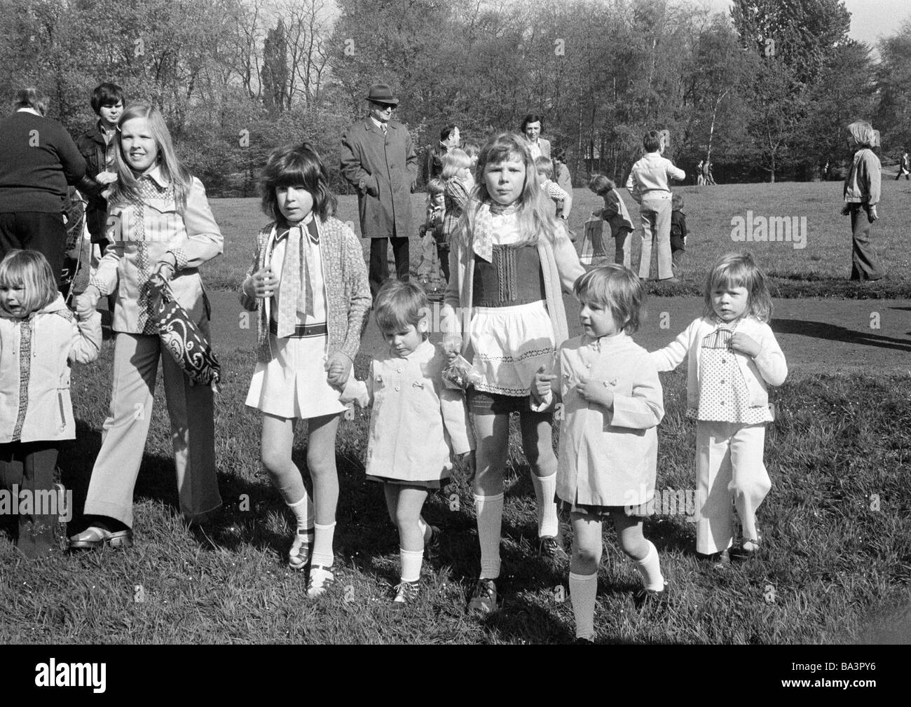 Seventies, black and white photo, people, children, childrens treat, group of young girls walk hand in hand across a large meadow, aged 3 to 12 years Stock Photo