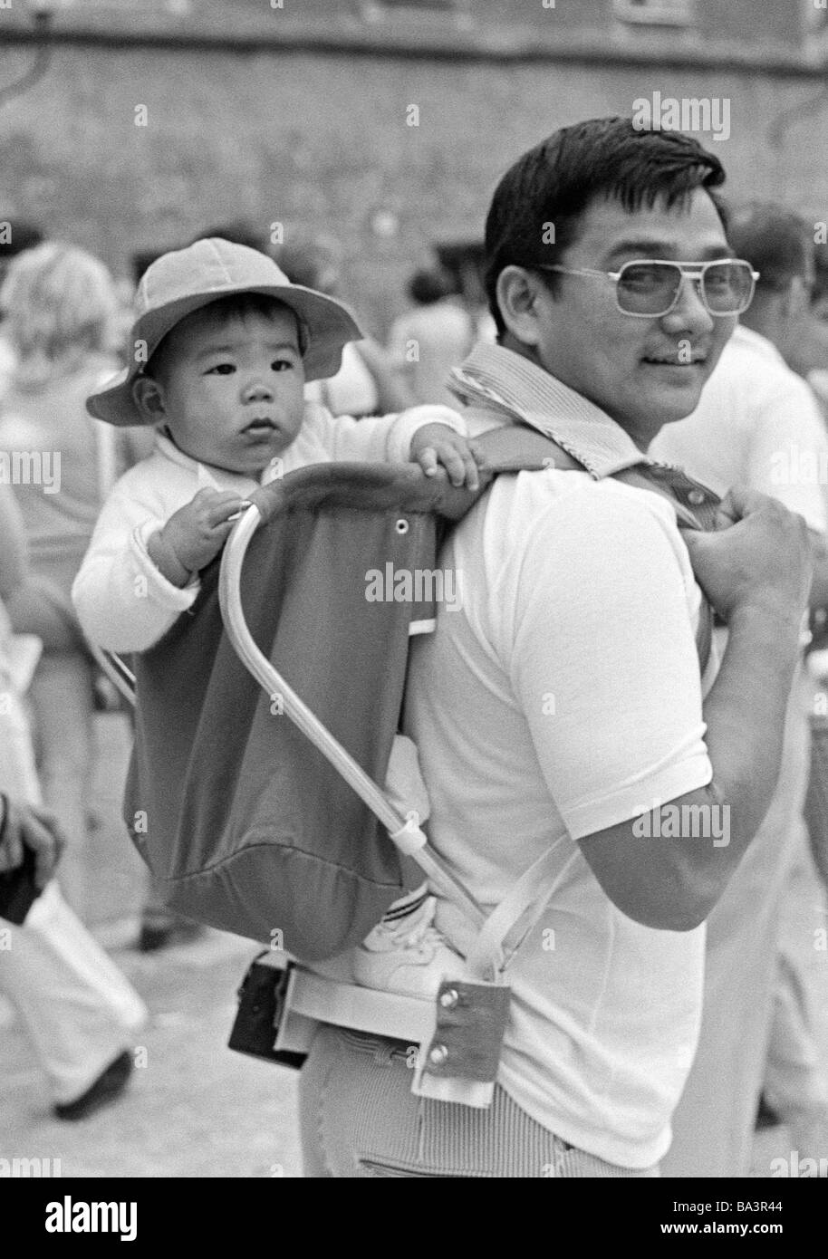 Seventies, black and white photo, people, young father carries the little son on his back in a knapsack, Japanese, tourists, aged 25 to 35 years, aged 1 to 2 years, Austria, Salzburg Stock Photo