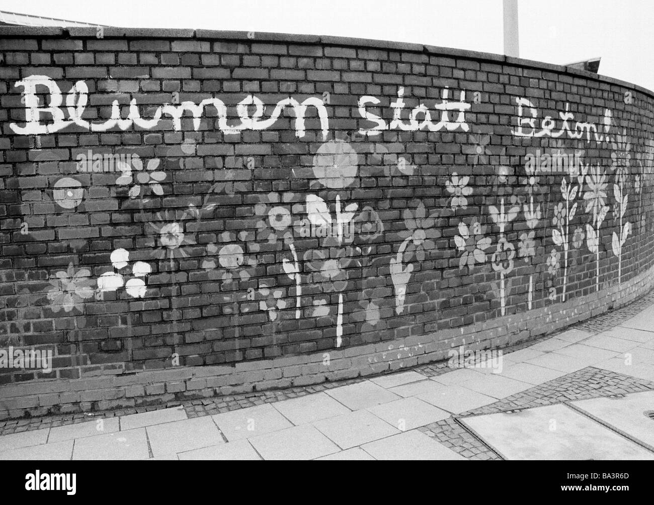 Eighties, black and white photo, ecology, brick wall painted with flowers, slogan 'flowers rather than beton' Stock Photo