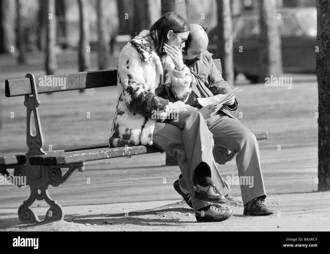 Seventies, black and white photo, people, couple sits on a bench viewing a road map, aged 30 to 40 years, France, Paris Stock Photo