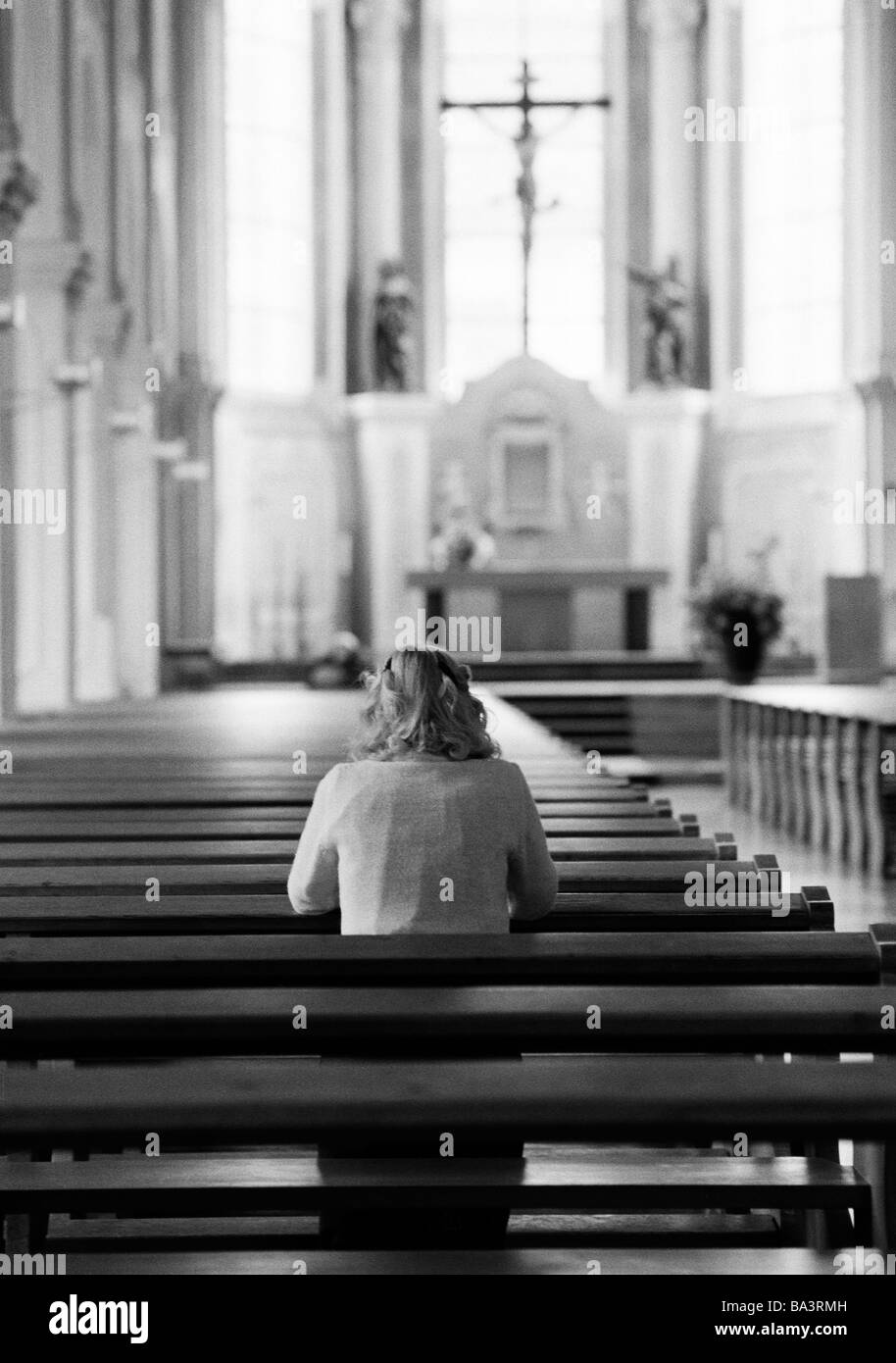 Eighties, black and white photo, religion, Christianity, young woman kneels in a pew and prays, aged 30 to 35 years, Elisabeth Stock Photo