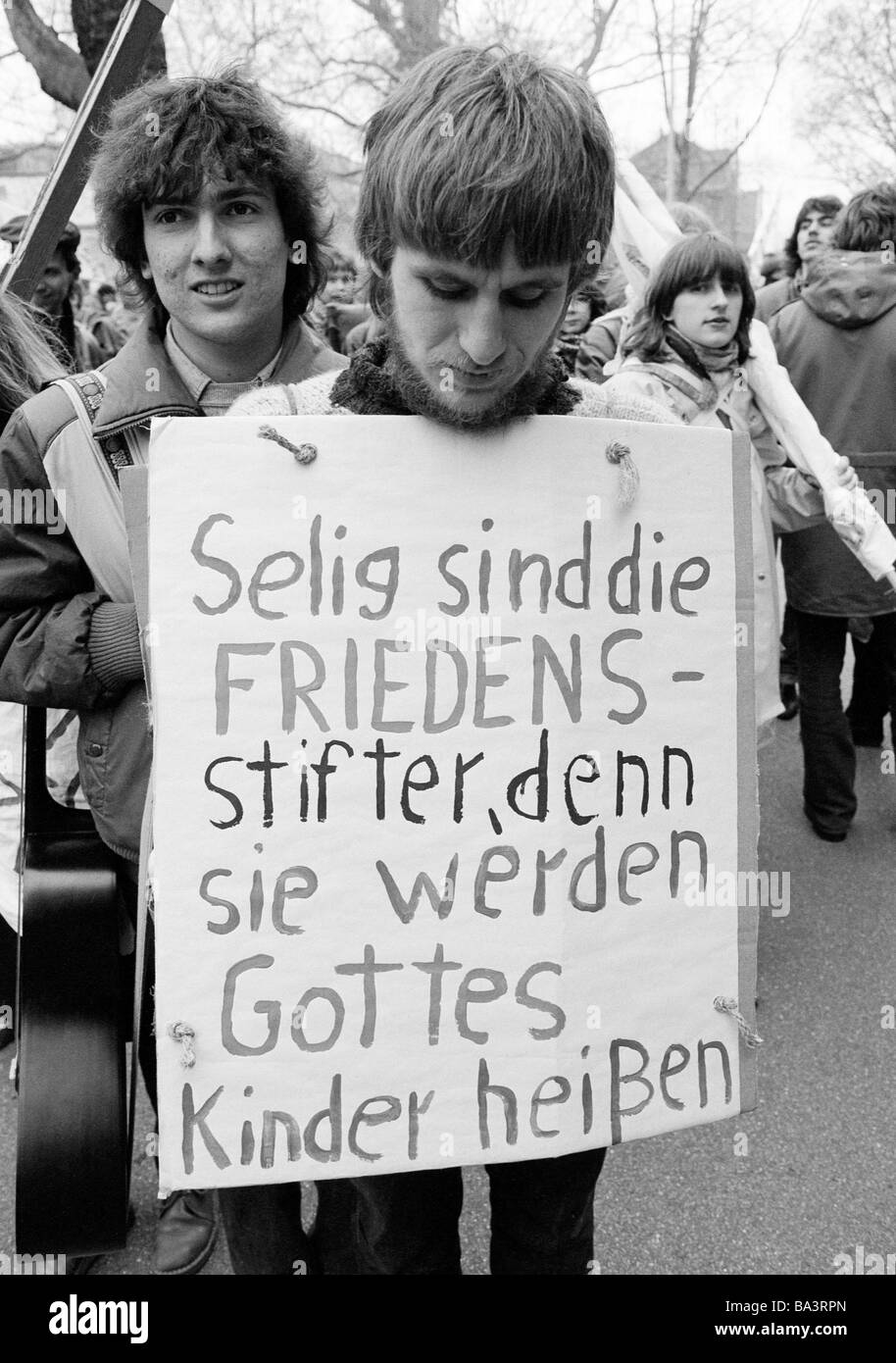 Eighties, black and white photo, people, peace demonstration, Easter marches 1983 in Germany against nuclear armament, young man presents a protest sign, aged 20 to 25 years, D-Oberhausen, Ruhr area, North Rhine-Westphalia Stock Photo
