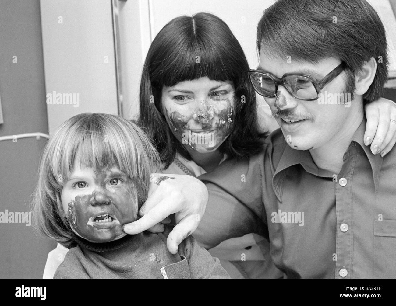 Seventies, black and white photo, people, young family, one child, parents play with the daughter, finger colouring, man, aged 30 to 40 years, woman, aged 30 to 35 years, girl, aged 3 to 4 years, Wolfgang, Ria, Kathrin Stock Photo