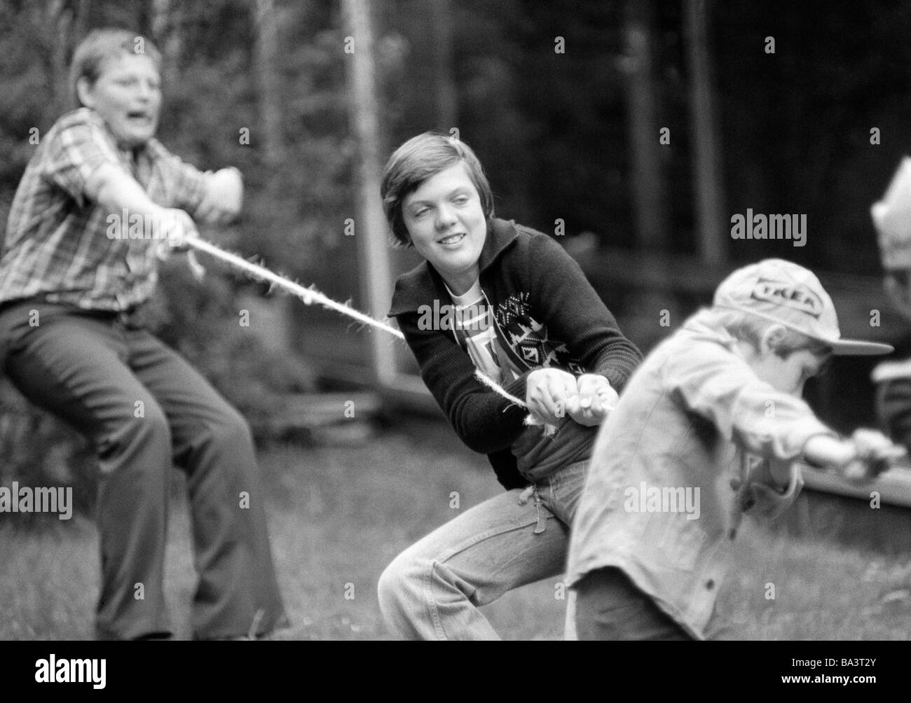 Seventies, black and white photo, people, children, boys, tug-of-war, childrens playground, aged 10 to 13 years Stock Photo