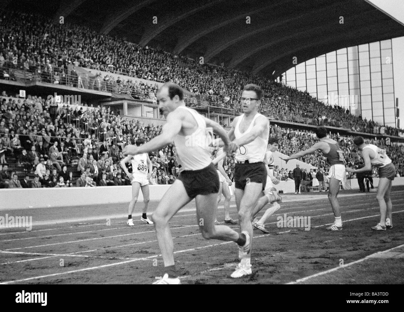 Sixties, black and white photo, sports, athletics, German Championships in Athletics 1965 in Duisburg, Wedau Stadium, nowadays MSV Arena, track racing, 4 x 400 metres relay, men, last changeover of the German champion ASC Darmstadt by Fritz Roth to Manfred Hanika, relay runners were Wilfried Braun, Manfred Hanika, Fritz Roth and Dirk von Maltitz, D-Duisburg, Rhine, Ruhr area, North Rhine-Westphalia Stock Photo