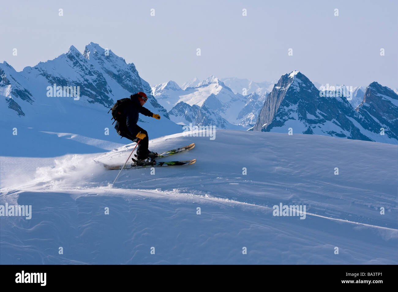 Alpine skier skiing on the Juneau Ice Field and Rhino Peak in the background in Southeast Alaska. Composite Stock Photo