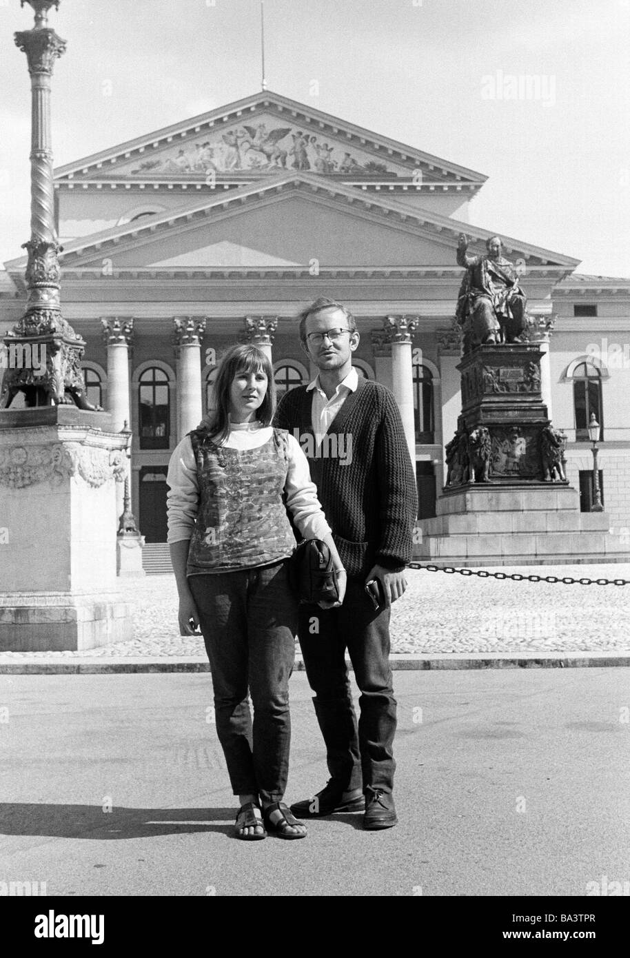 Sixties, black and white photo, people, young couple, posing, holidays, holidaymakers, aged 25 to 35 years, Max Joseph Square, National Theatre, monument, statue, Max I Joseph, King Maximilian I of Bavaria, D-Munich, Isar, Upper Bavaria, Bavaria Stock Photo