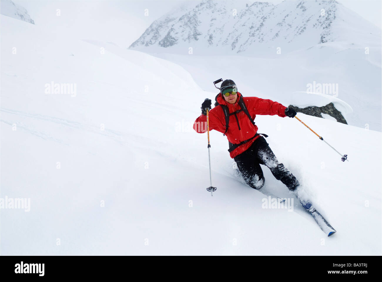 Man makes telemark turns while backcountry skiing in the Thompson Pass area just north of Valdez, Alaska during Winter Stock Photo