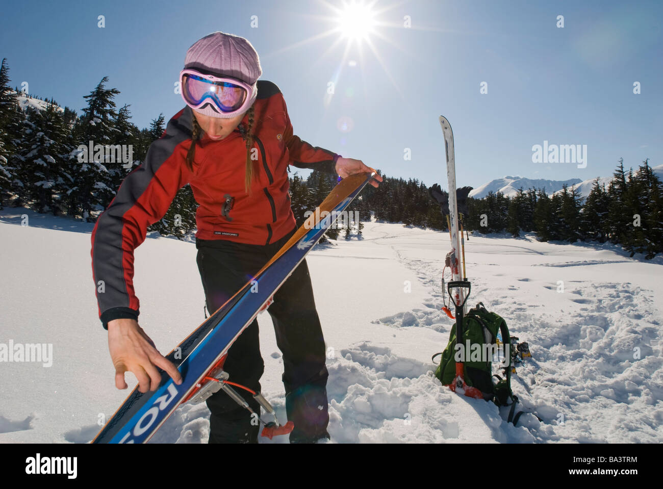 Woman prepares for backcountry skiing in Turnagain Pass of Southcentral Alaska during Winter Stock Photo