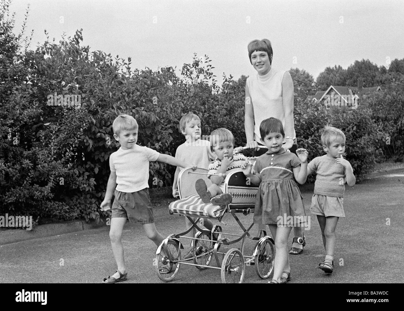 Seventies, black and white photo, education, parenting, child education, Kindergarten, childrens nurse, fostress, aged 18 to 20 years, children, boys, girls, aged 3 to 5 years, baby in a buggy, aged 1 to 2 years, walk, walking, stroll, strolling Stock Photo