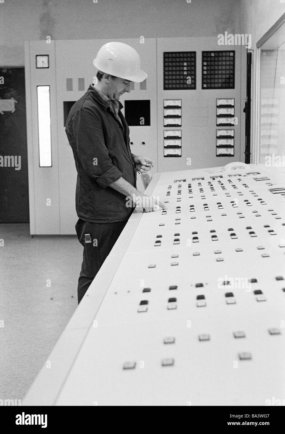 Seventies, black and white photo, business, man with hard hat stands at a control desk, aged 30 to 40 years, Ruhr area, North Rhine-Westphalia Stock Photo