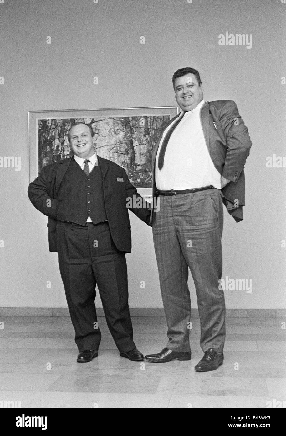 Seventies, black and white photo, humour, people, contrast, a runtish man  and a large-sized man stand side by side, dwarf and giant, aged 30 to 40  years Stock Photo - Alamy