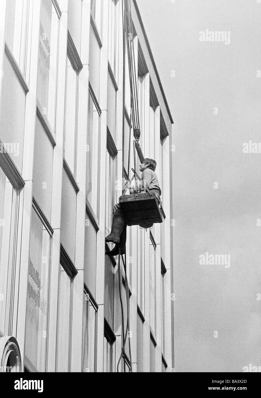 Seventies, black and white photo, occupation, window cleaner working on the frontage of a high-rise block, man, aged 25 to 35 years Stock Photo