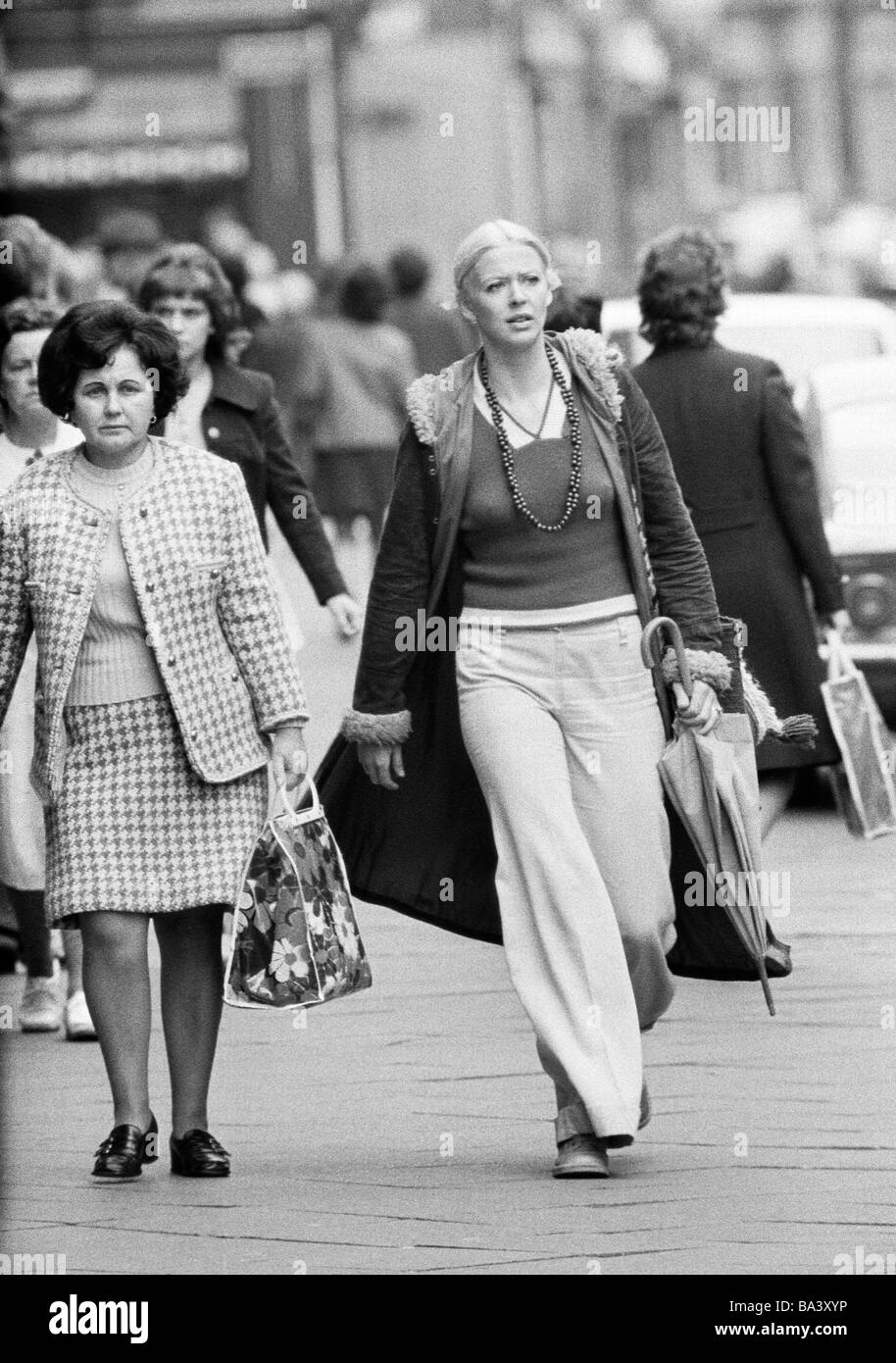 Seventies, black and white photo, people, young woman, aged 30 to 40 years,woman, aged 40 to 50 years, pulli, jacket, trousers, female suit, stroll along the pedestrian zone, shopping, shopping bag, umbrella, freetime Stock Photo