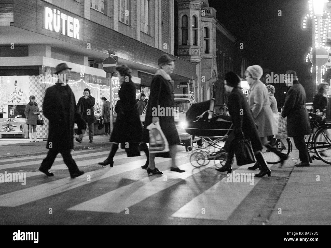 Seventies, black and white photo, people on shopping expedition, shopping street, pedestrian zone, zebra crossing, evening, illuminated, Market Street, D-Oberhausen, Ruhr area, North Rhine-Westphalia Stock Photo