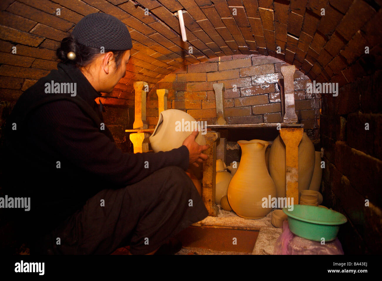 Potter sitting in ceramic kiln side view Stock Photo