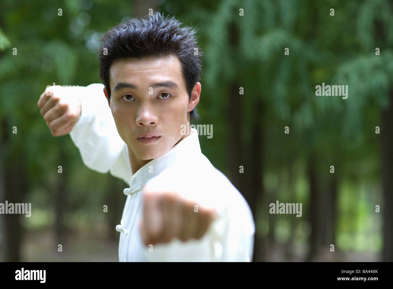 Young man wearing martial arts uniform performing the Kung Fu punching