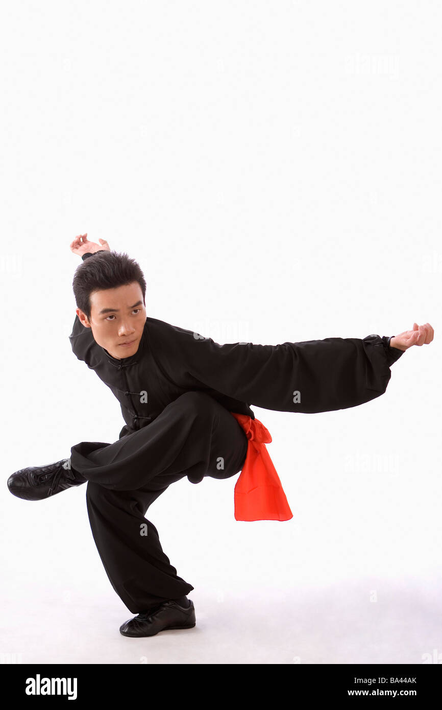 Young man wearing martial arts uniform performing the Kung Fu eagle
