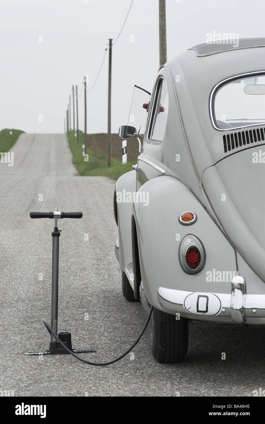 Oldtimer VW-bugs car car-breakdown detail banquets air-pump flat nobody edge-strips country road parked stopped gray year of Stock Photo