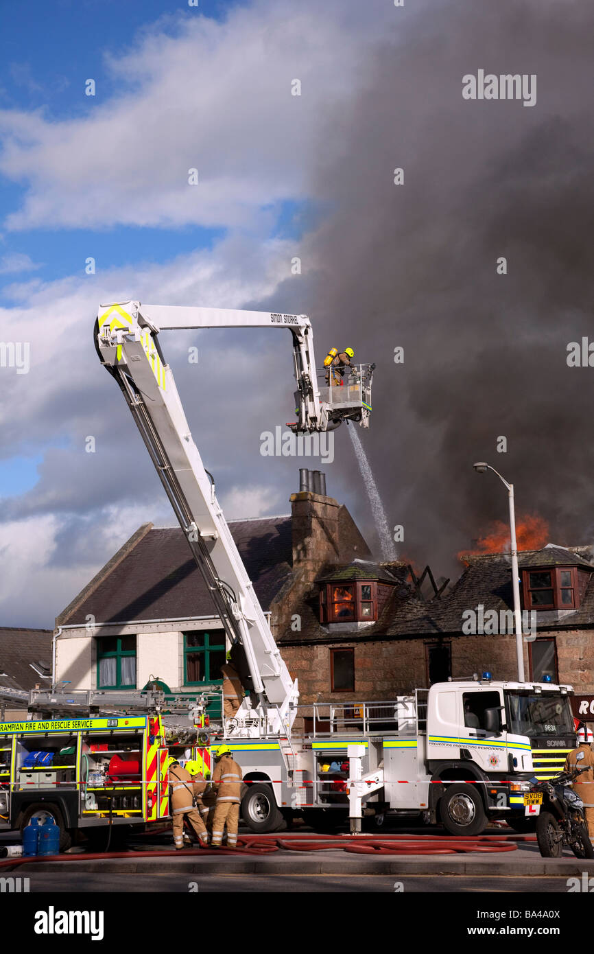 Firemen fighting Shop fire. Firefighter at scene at George Strachan’s of Aboyne, Aberdeenshire, Scotland Stock Photo