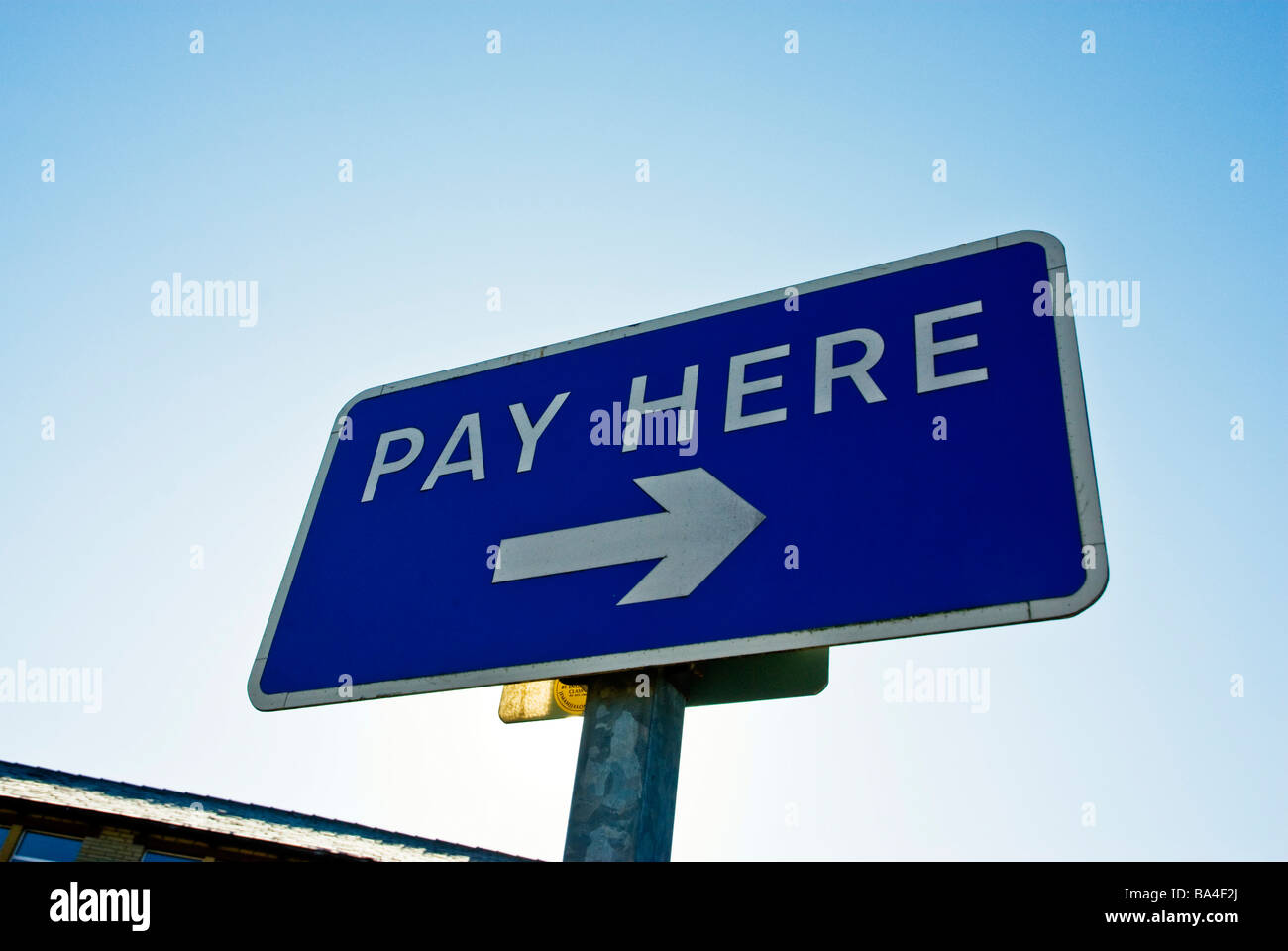 Pay Here sign against a clear blue sky Stock Photo