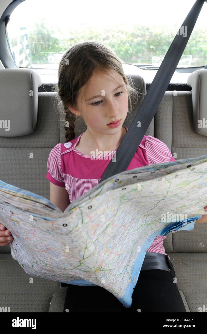 An 8 year old map reading in the back of a car Stock Photo