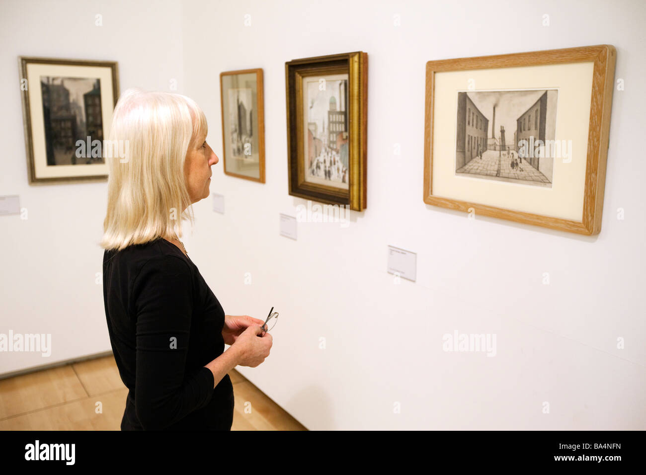 UK England Salford Quays Lowry Centre gallery woman looking at drawing ...