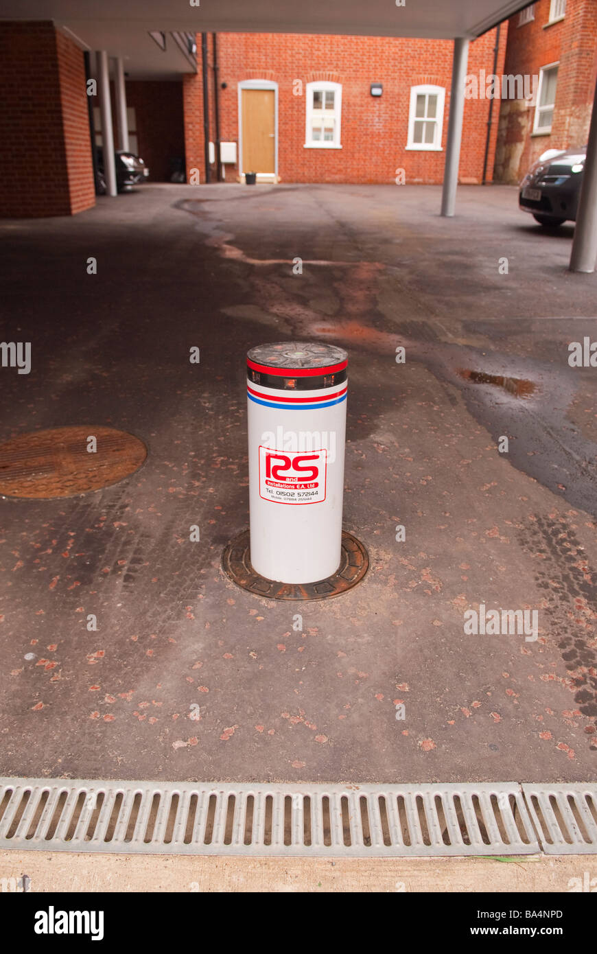 A bollard in a car park used to stop unauthorised cars entering Stock