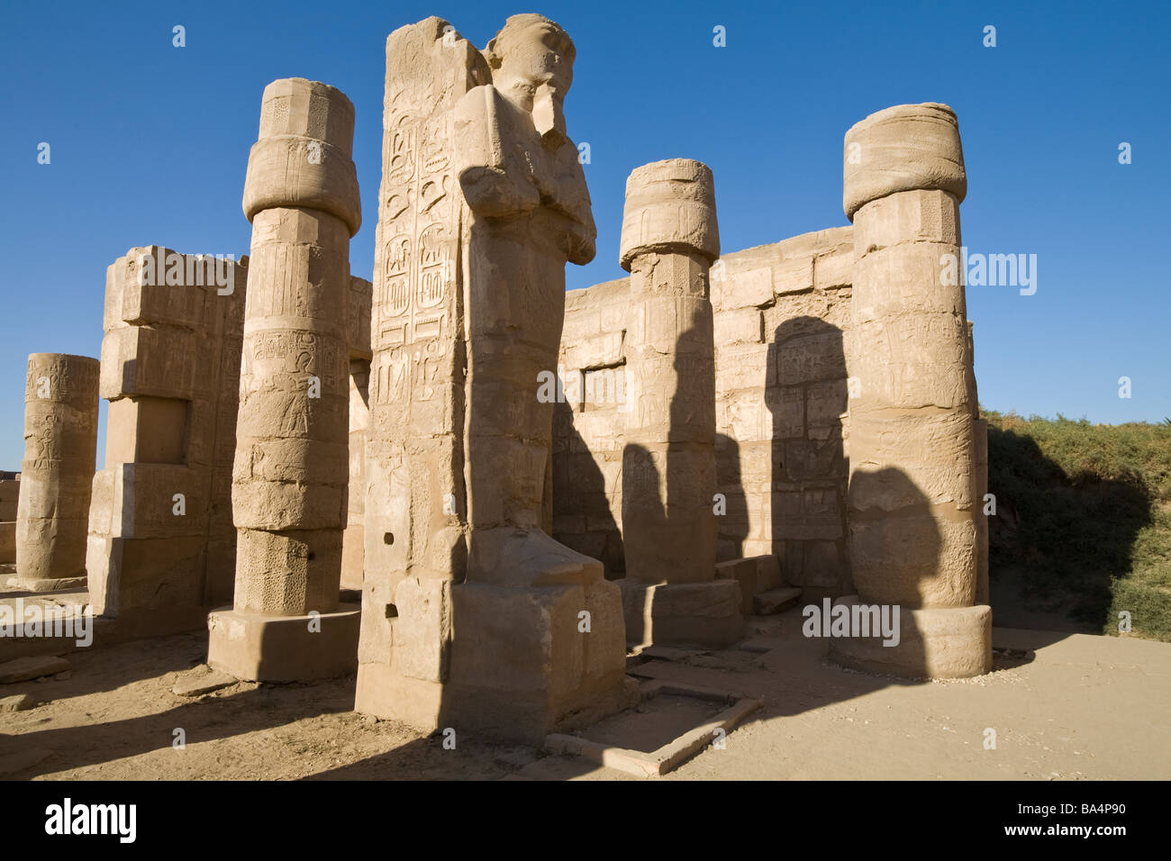 Osirid statue in late afternoon sun and shadows within Karnak Temple, Luxor Egypt Stock Photo
