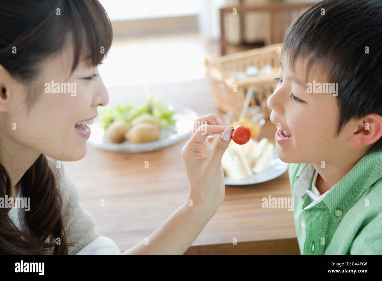 Mother feeding cherry to his son Stock Photo