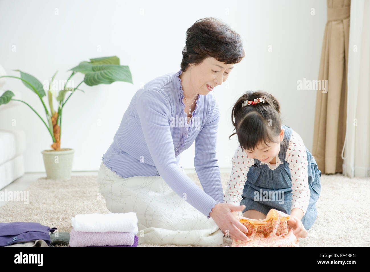 Girl with grandma folding clothes Stock Photo