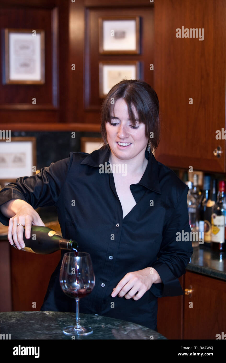 Stewardess pouring a glass of red wine for a guest aboard super yacht 'Big Aron' Stock Photo